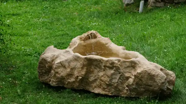 Brunnen mit Skulptur „Froschchor“ aus einem naturbelassenen Kalksteinrohling