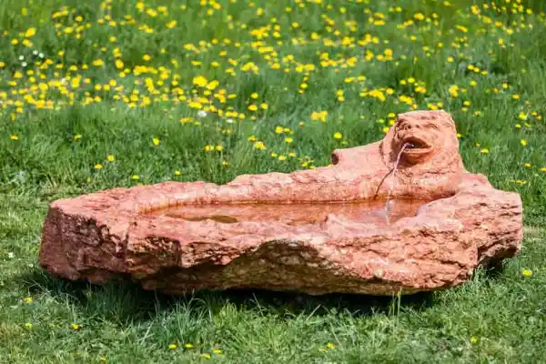Großer Gartenbrunnen aus rotem Kalkstein mit Bärenkopf